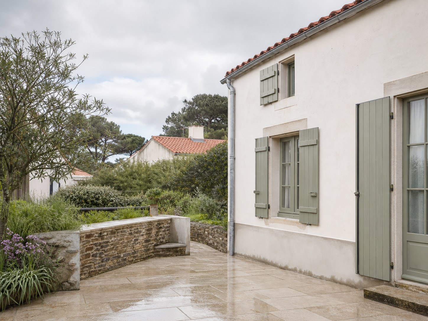 Façade claire, dallage et muret rénovés dans un environnement de Loire-Atlantique